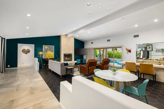 a living room with fireplace furniture and a large window