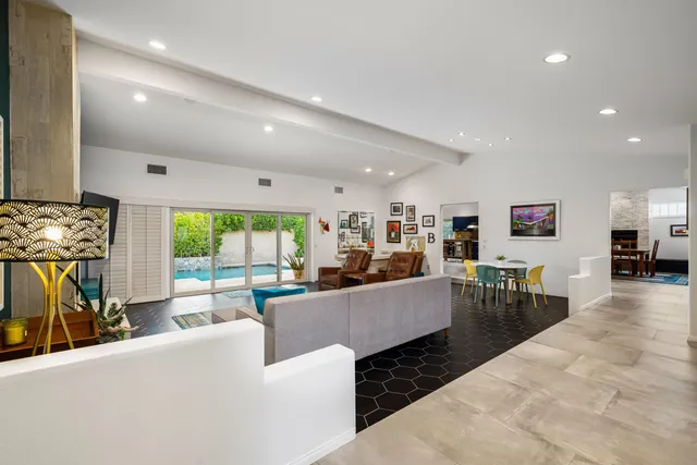a living room with furniture a flat screen tv and a large window
