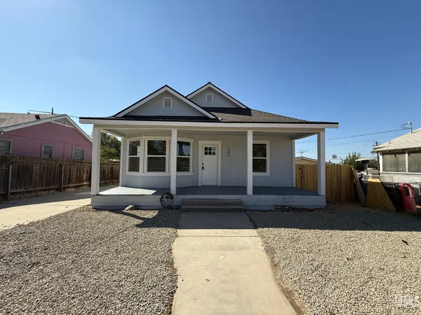 a front view of a house with a yard and seating space