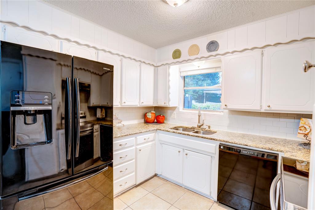 6028 Ridgecrest Drive Watauga, TX 76148 - Photo 11 of 40 a kitchen with a sink cabinets stainless steel appliances and a window