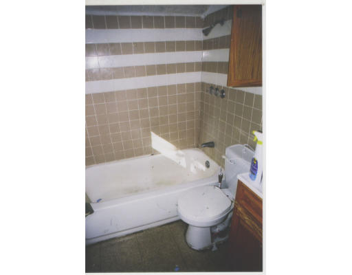 9 Lander Street Lynn, MA 01902 - Photo 3 of 4 a white toilet sitting next to a bathtub