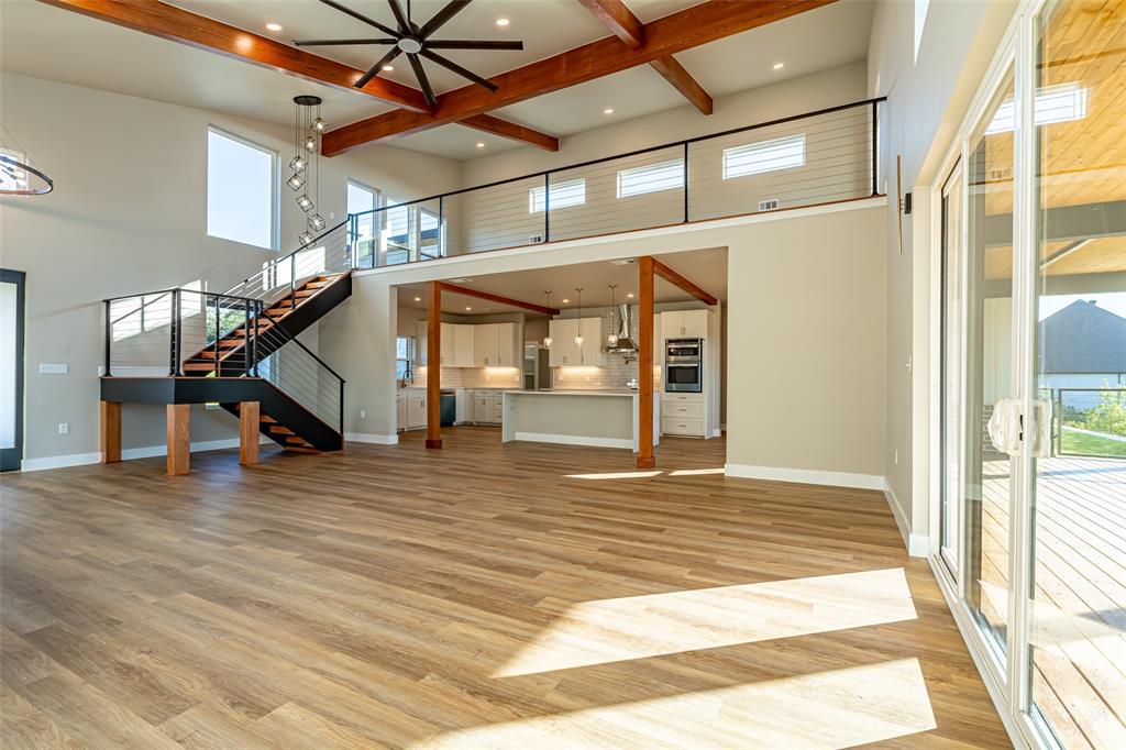 2128 Eagles Rdg Drive Weatherford, TX 76087 - Photo 25 of 39 Unfurnished living room with beamed ceiling, stairway, light wood finished floors, recessed lighting, and a high ceiling