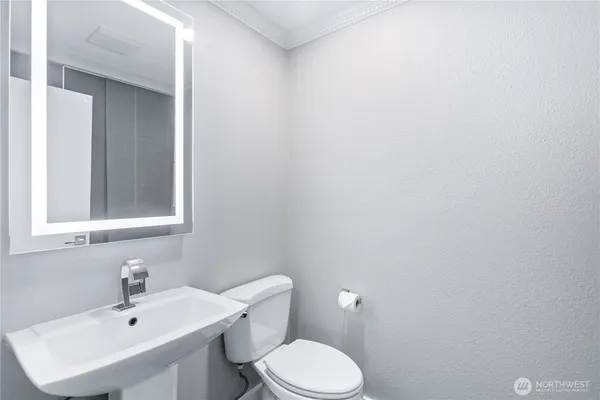 a bathroom with a sink mirror and toilet