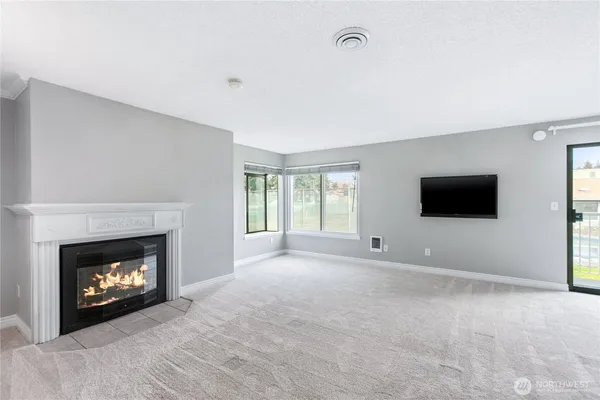a view of an empty room with a fireplace and a window