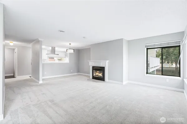 an empty room with windows and fireplace