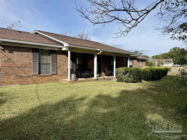 a view of a house with backyard and porch