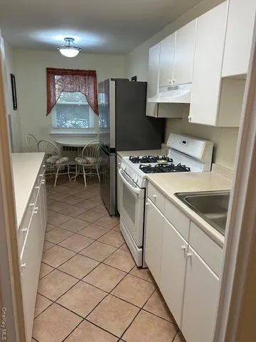 a kitchen with stainless steel appliances a stove a sink and a refrigerator
