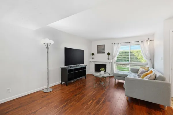 a living room with furniture a flat screen tv and a large window