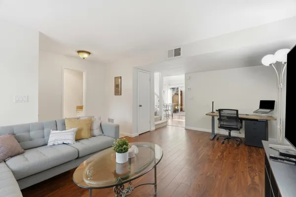 a living room with furniture wooden floor and a table