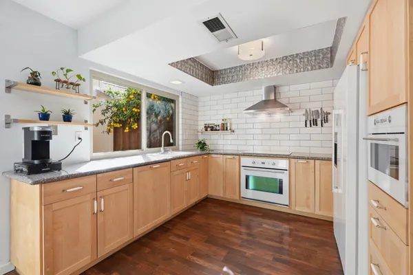 a kitchen with stainless steel appliances granite countertop a stove a sink and a refrigerator
