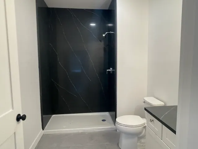 a bathroom with a toilet and a shower