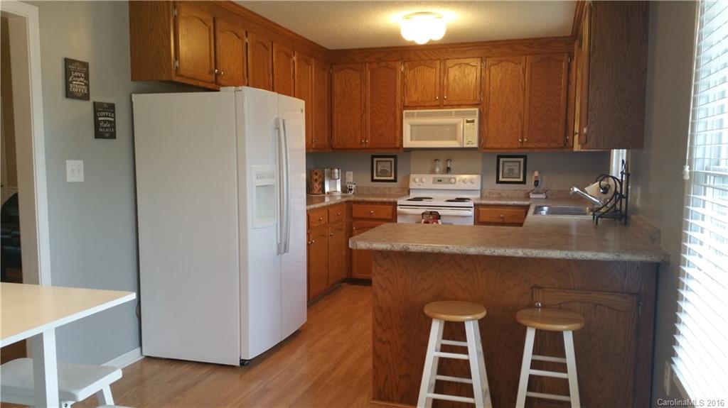 1348 Lawrence Road Clover, SC 29710 - Photo 4 of 21 a kitchen with a refrigerator a stove a sink and dishwasher with wooden floor