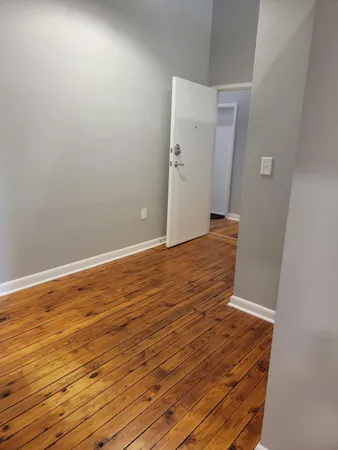 a view of an empty room with wooden floor