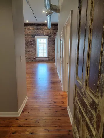 an empty room with wooden floor and staircase