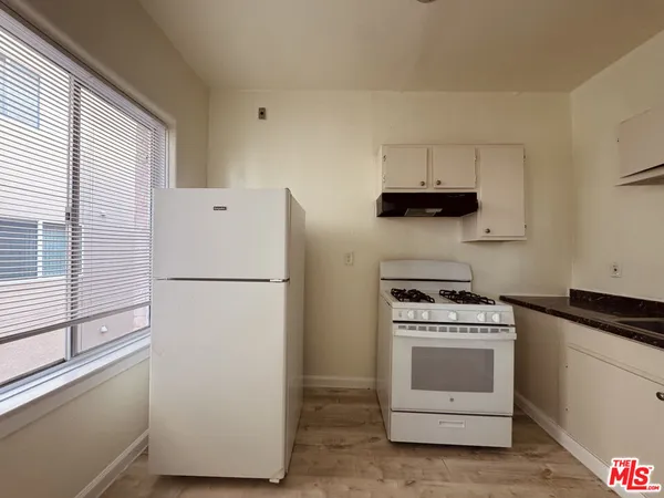 a white refrigerator freezer and a stove sitting inside of a kitchen