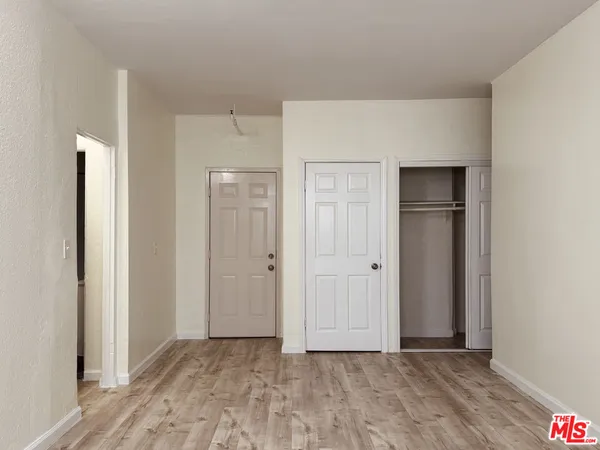 a view of an empty room with closet and a window