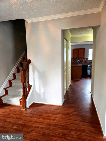 a view of a hallway with wooden floor and stairs