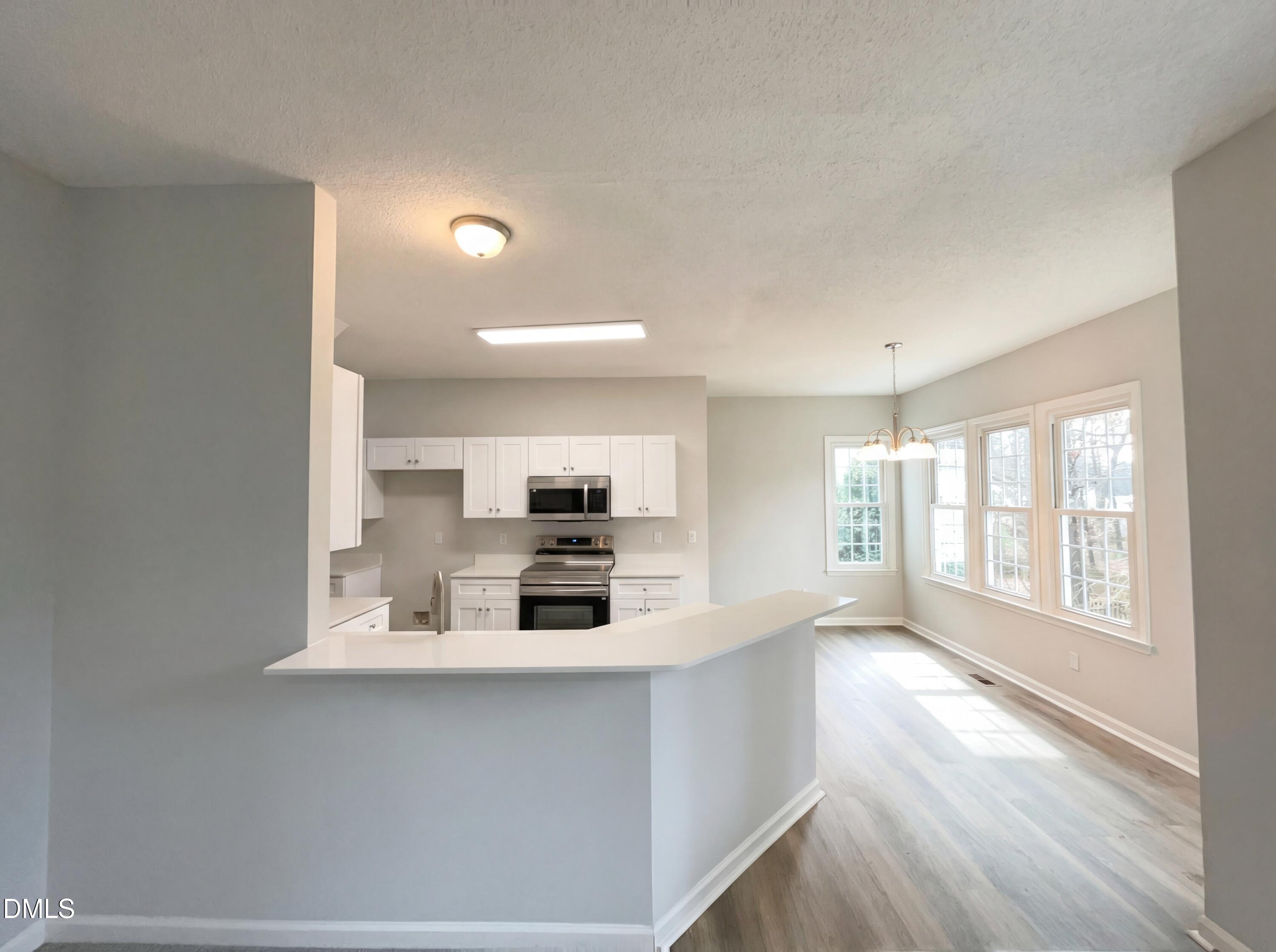 12213 Freemont Lane Raleigh, NC 27613 - Photo 17 of 19 a kitchen with stainless steel appliances a sink a stove a microwave a refrigerator and cabinets