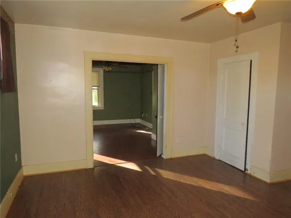 an empty room with wooden floor and closet