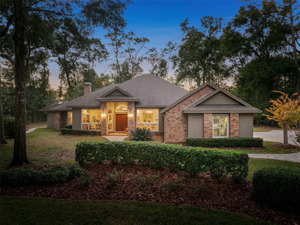 a front view of a house with a yard and trees