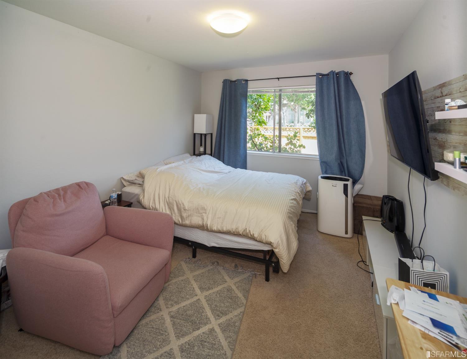 1455 Bay Street Alameda, CA 94501 - Photo 27 of 39 a bedroom with a bed a couch and a flat tv screen on the dresser