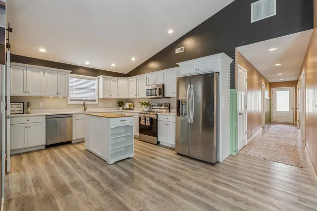 a kitchen with a refrigerator a sink and cabinets