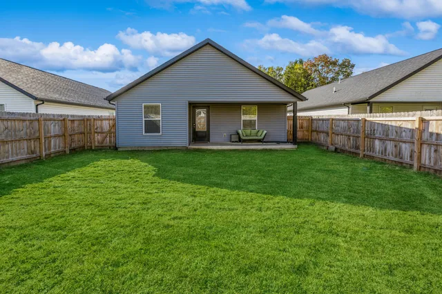 a view of a house with a yard and porch