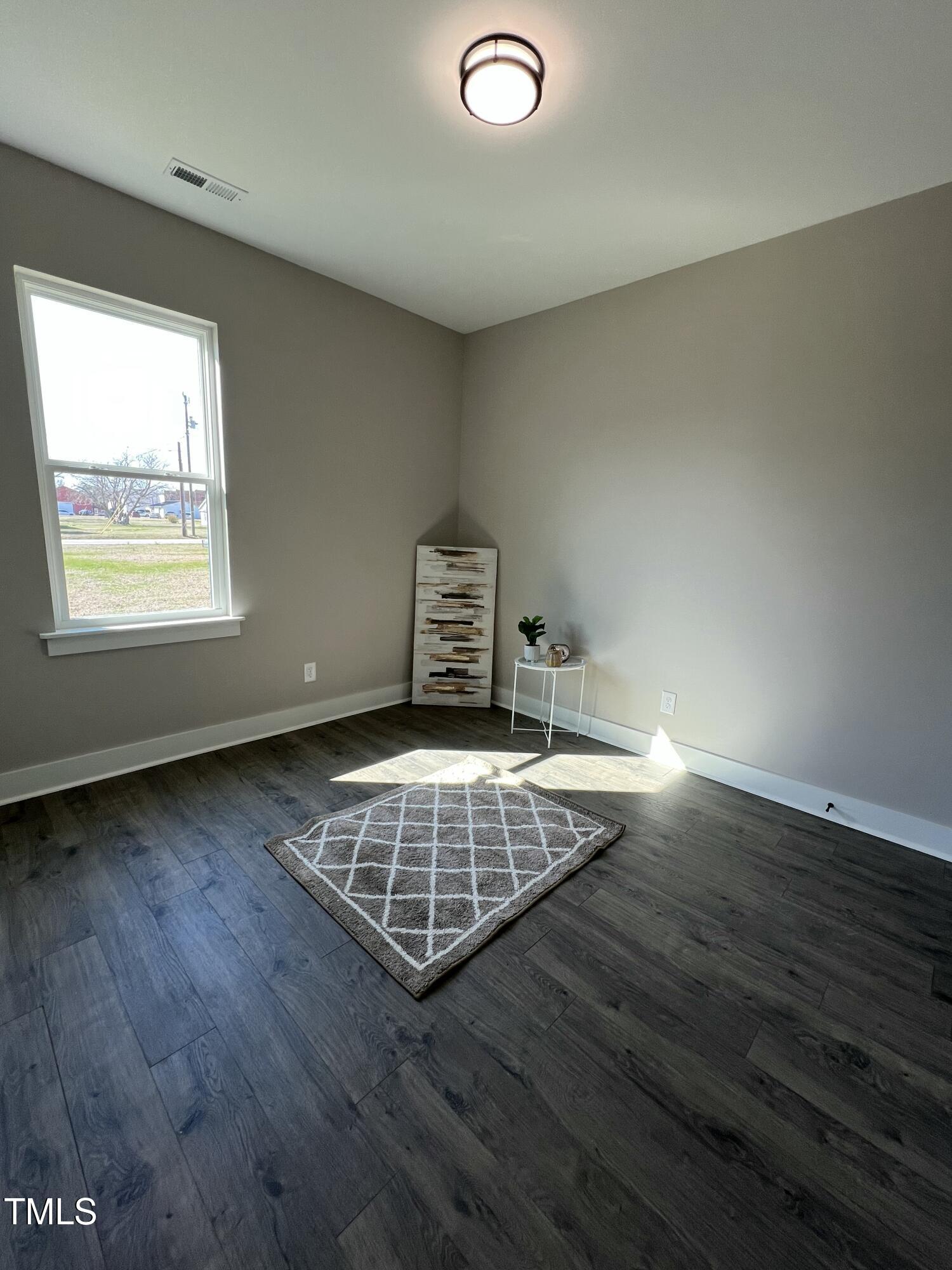 151 East Washington Street Coats, NC 27521 - Photo 13 of 44 an empty room with wooden floor and window