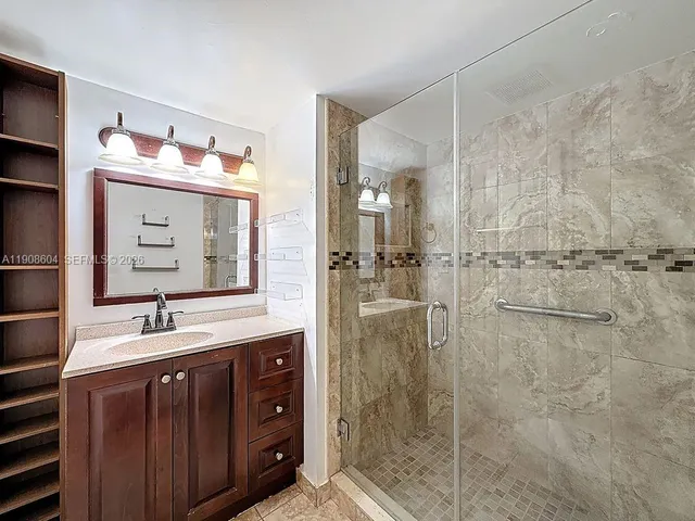 a bathroom with a double vanity sink mirror and shower