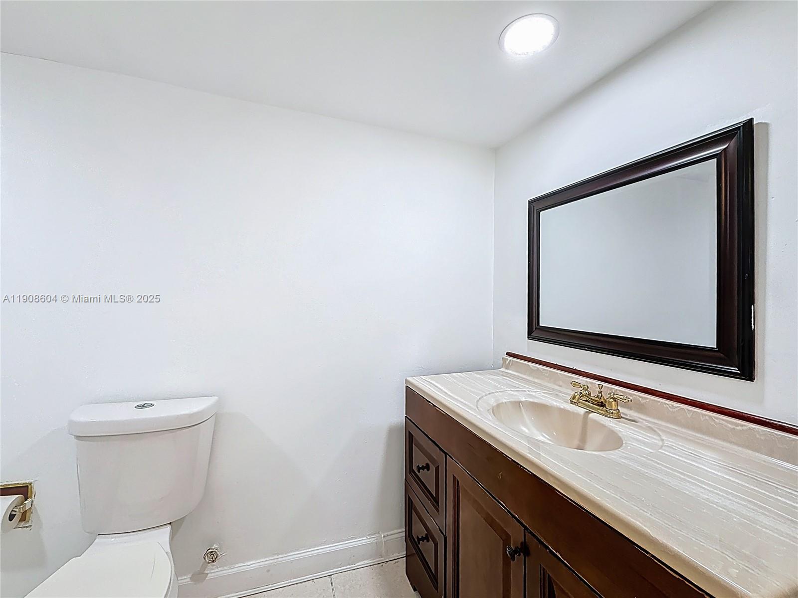 17600 Northwest 68th Avenue, Unit B2004 Hialeah, FL 33015 - Photo 8 of 24 a bathroom with a toilet sink and mirror