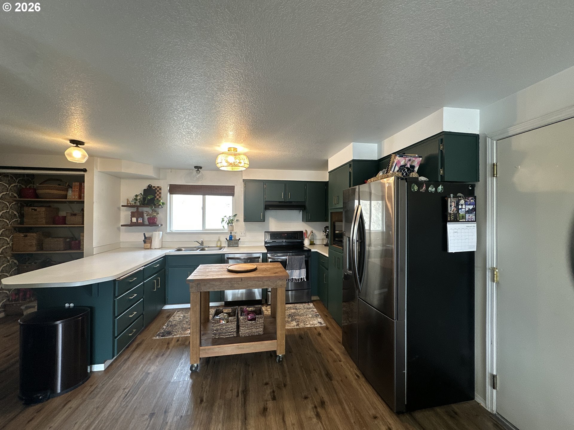120 Valley View Drive John Day, OR 97845 - Photo 7 of 34 a kitchen with stainless steel appliances a refrigerator a sink dishwasher a stove and white cabinets with wooden floor