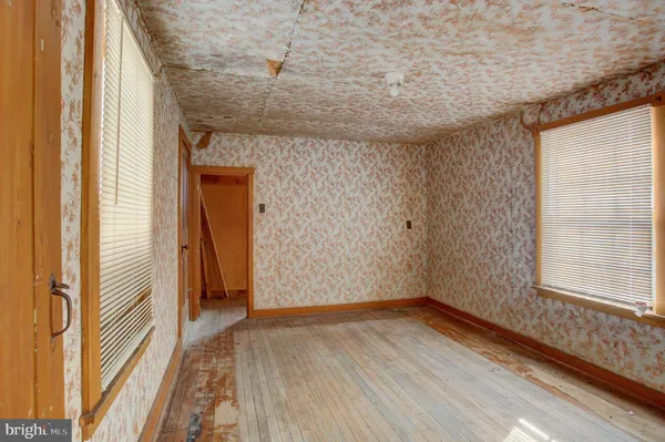 a view of a hallway with wooden floor and a window