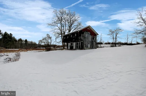 a view of a house with a yard covered in snow