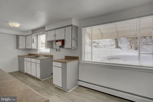 a kitchen with granite countertop white cabinets and white appliances