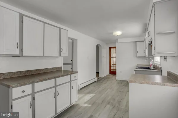 a kitchen with granite countertop white cabinets and refrigerator