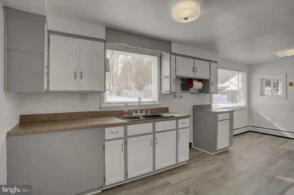 a kitchen with granite countertop white cabinets and white appliances