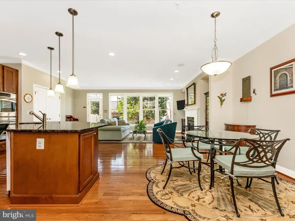 a kitchen with stainless steel appliances kitchen island granite countertop a stove a refrigerator a kitchen island a sink and cabinets
