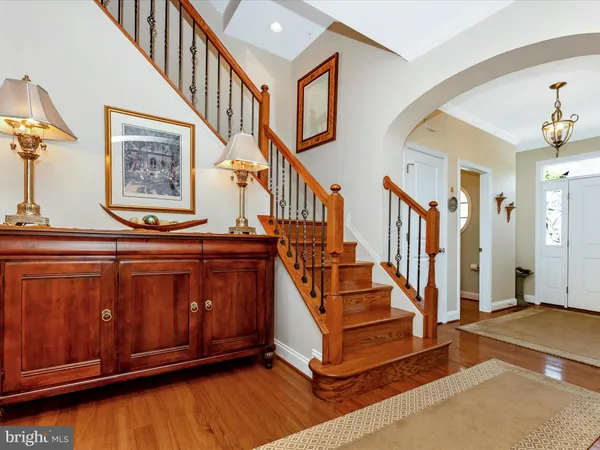 a dining room with wooden floor a chandelier a wooden table and chairs