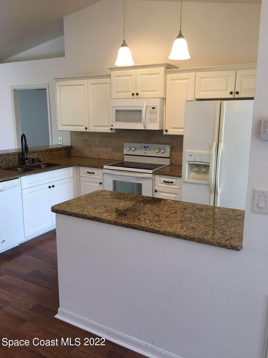 3794 Town Square Boulevard Melbourne, FL 32901 - Photo 11 of 18 a kitchen with stainless steel appliances granite countertop a sink stove and refrigerator