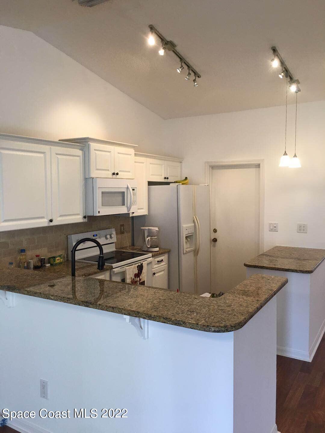 3794 Town Square Boulevard Melbourne, FL 32901 - Photo 8 of 18 a kitchen with granite countertop a sink a counter and cabinets