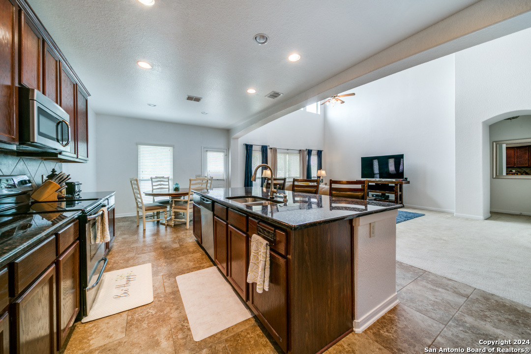 3113 Cameron River Schertz, TX 78108 - Photo 11 of 24 a kitchen with kitchen island stainless steel appliances a sink stove top oven and cabinets