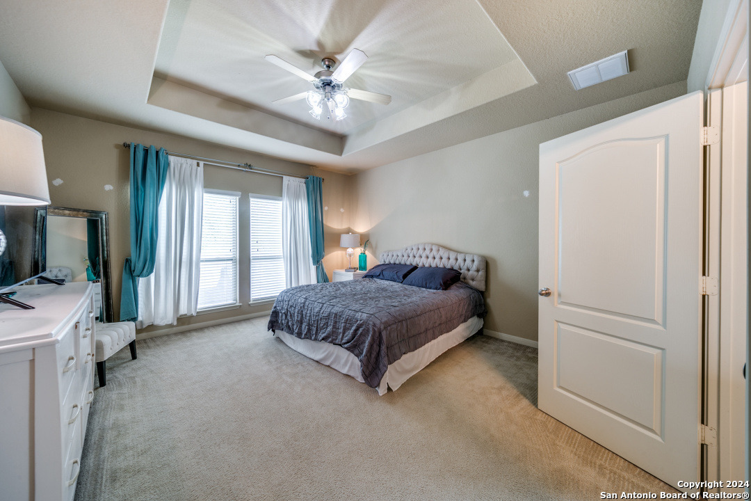 3113 Cameron River Schertz, TX 78108 - Photo 15 of 24 a bedroom with a large bed and a chandelier