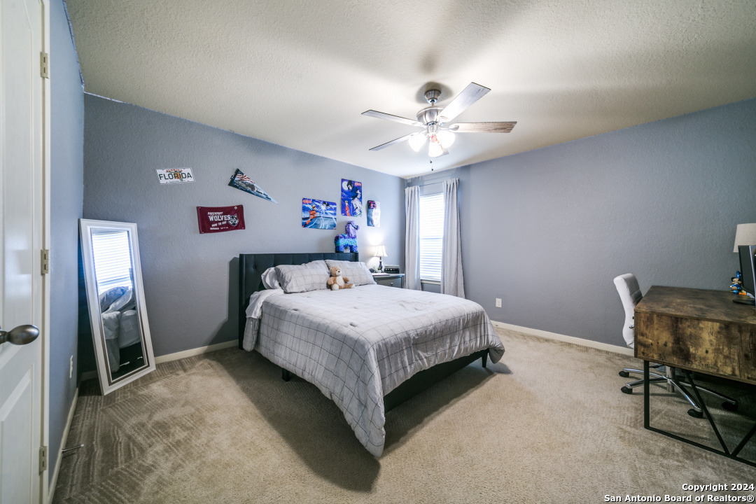3113 Cameron River Schertz, TX 78108 - Photo 20 of 24 a bedroom with a bed and a chandelier