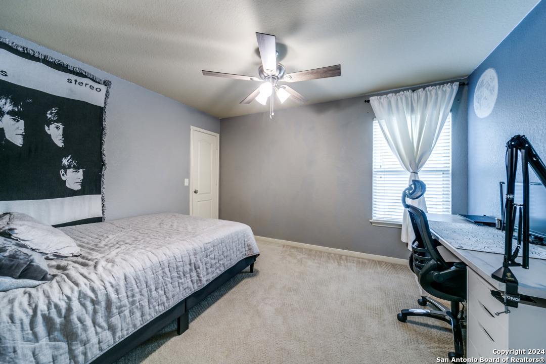 3113 Cameron River Schertz, TX 78108 - Photo 21 of 24 a bedroom with a bed and a chandelier