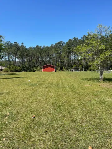 a view of a field with trees in the background