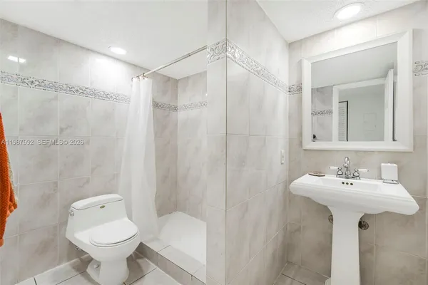 a bathroom with a sink toilet and shower