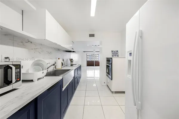 a kitchen with stainless steel appliances granite countertop a refrigerator and a stove