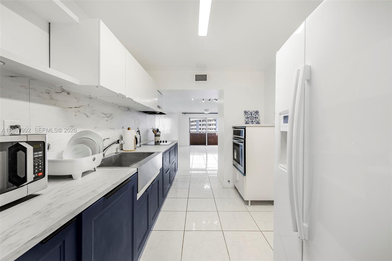 18001 North Bay Road, Unit 505 Sunny Isles Beach, FL 33160 - Photo 5 of 16 a kitchen with stainless steel appliances granite countertop a refrigerator and a stove