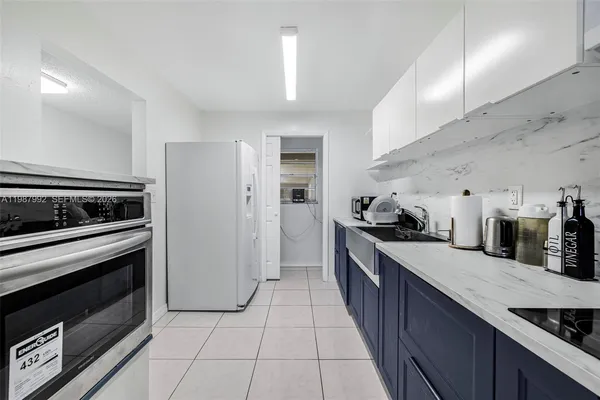 a large kitchen with stainless steel appliances granite countertop a stove a sink and a refrigerator