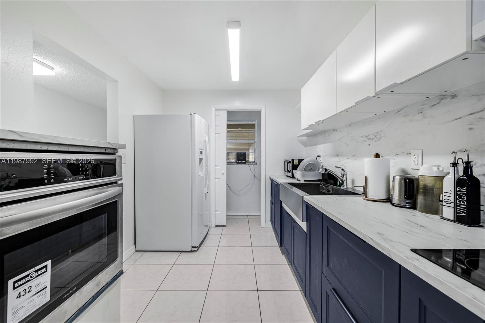 18001 North Bay Road, Unit 505 Sunny Isles Beach, FL 33160 - Photo 6 of 16 a large kitchen with stainless steel appliances granite countertop a stove a sink and a refrigerator